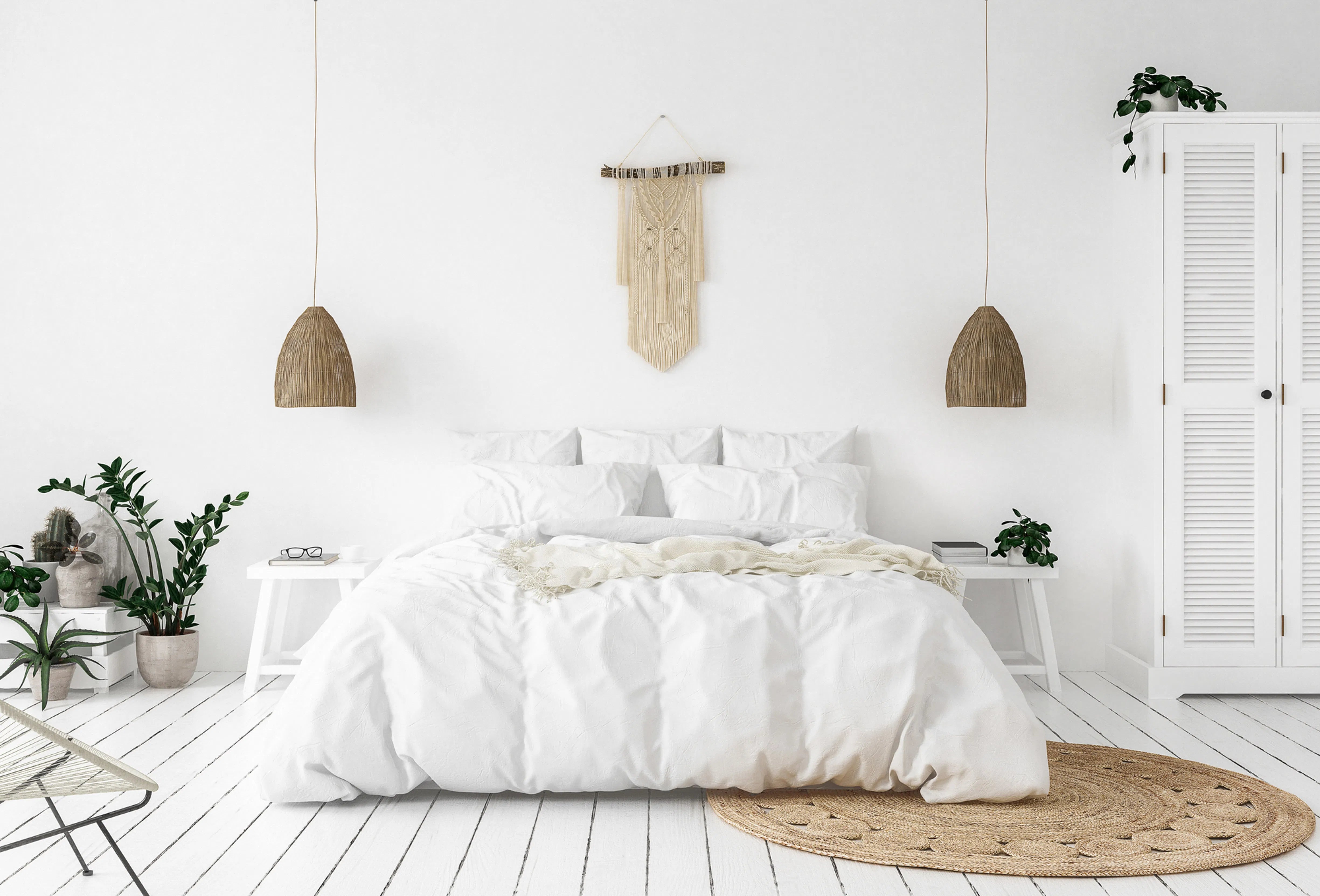 Bright, airy bedroom with a minimalist white bed, matching bedside tables and a louvred wardrobe