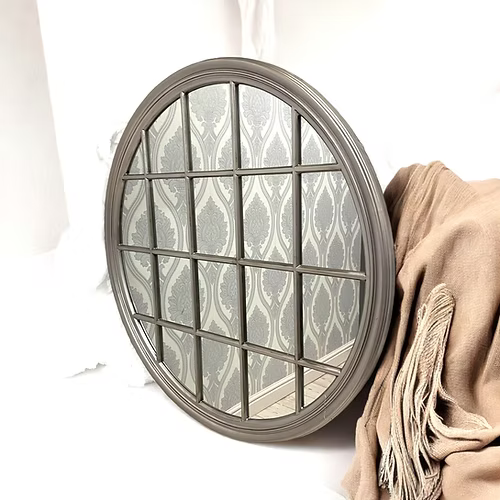 Round decorative mirror with a glass panel on a white background