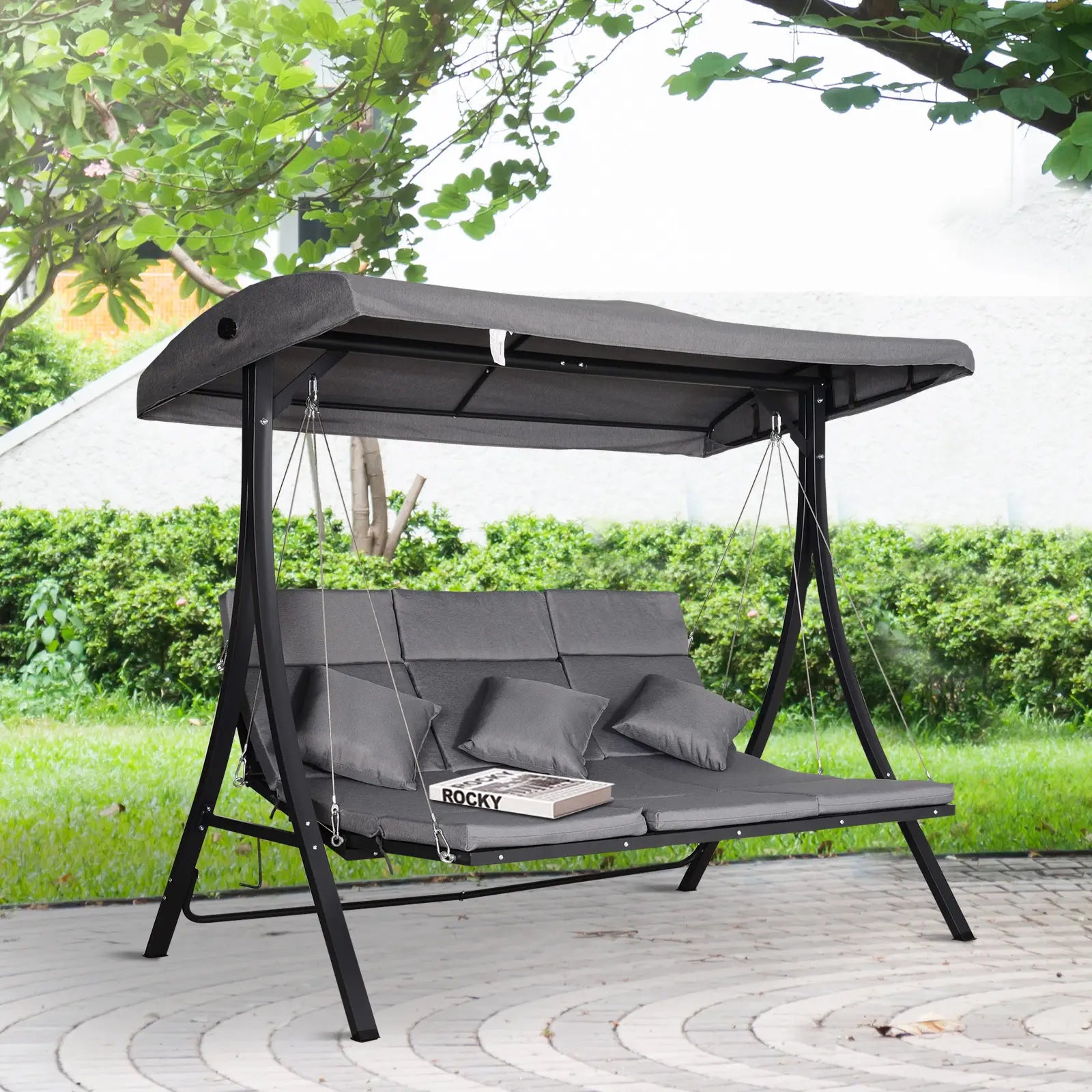 Gray swing chair with canopy in a garden setting