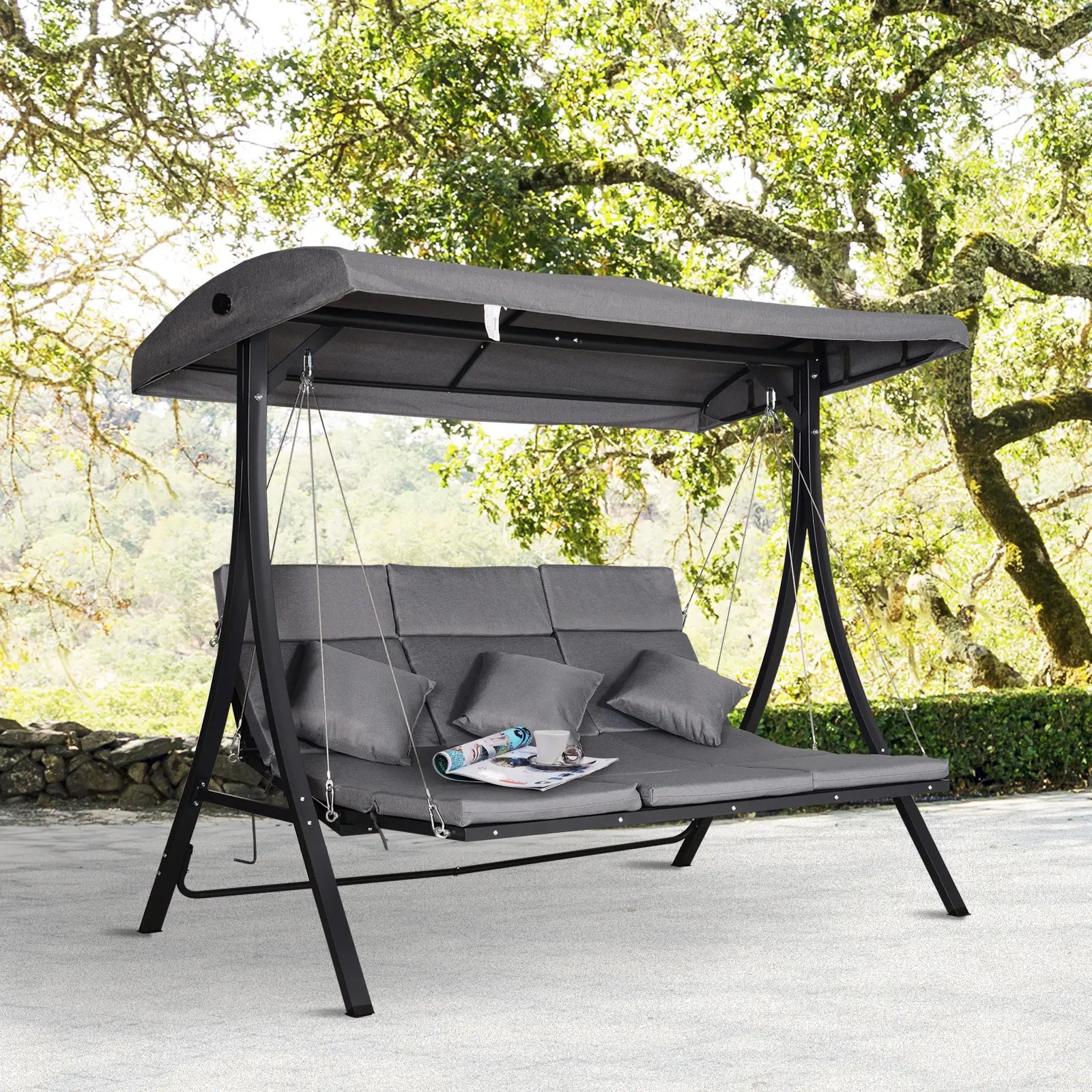 Gray outdoor swing with canopy in a garden setting