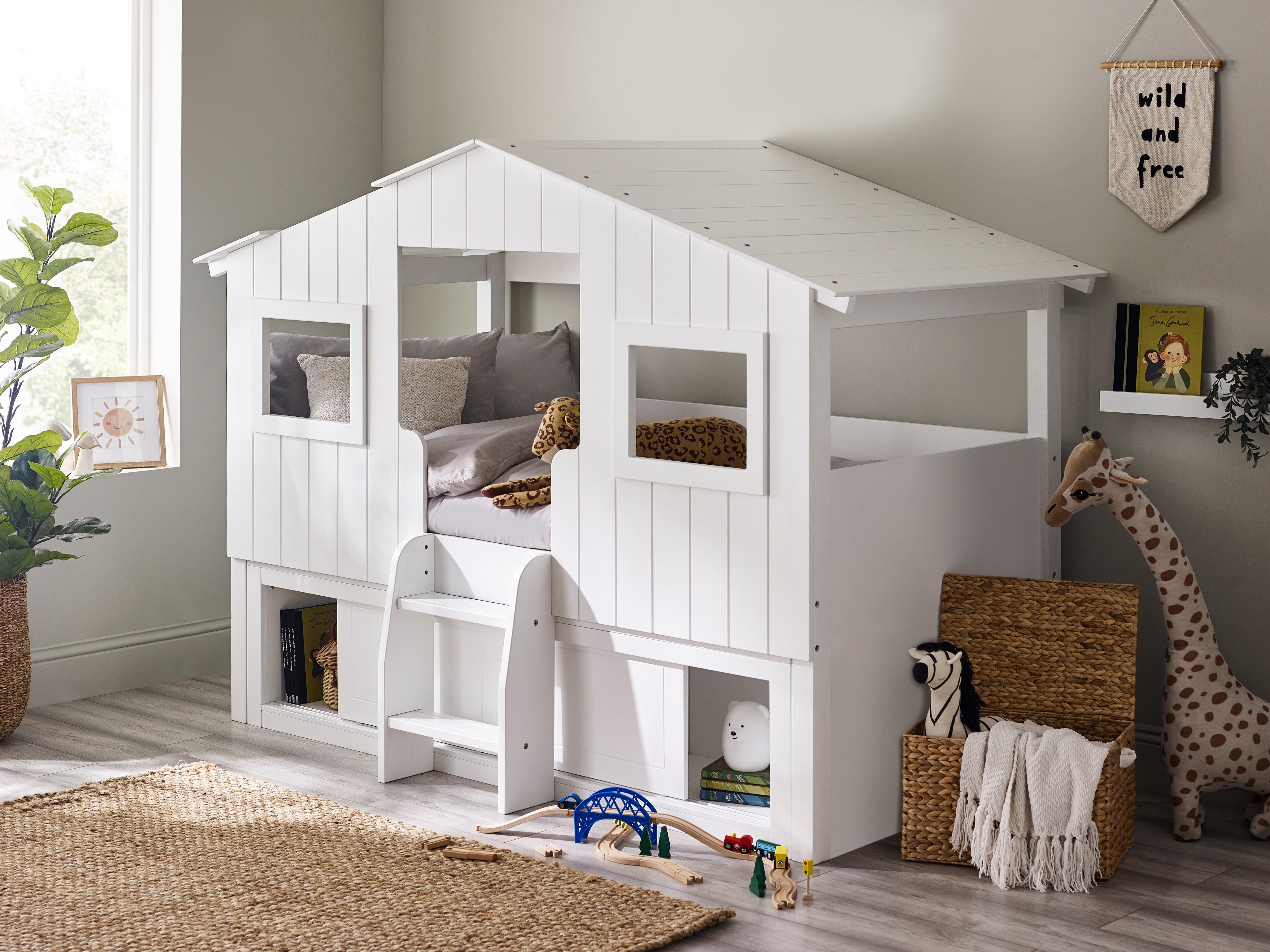 Children's room with a white playhouse bed, toys, and decorative items.