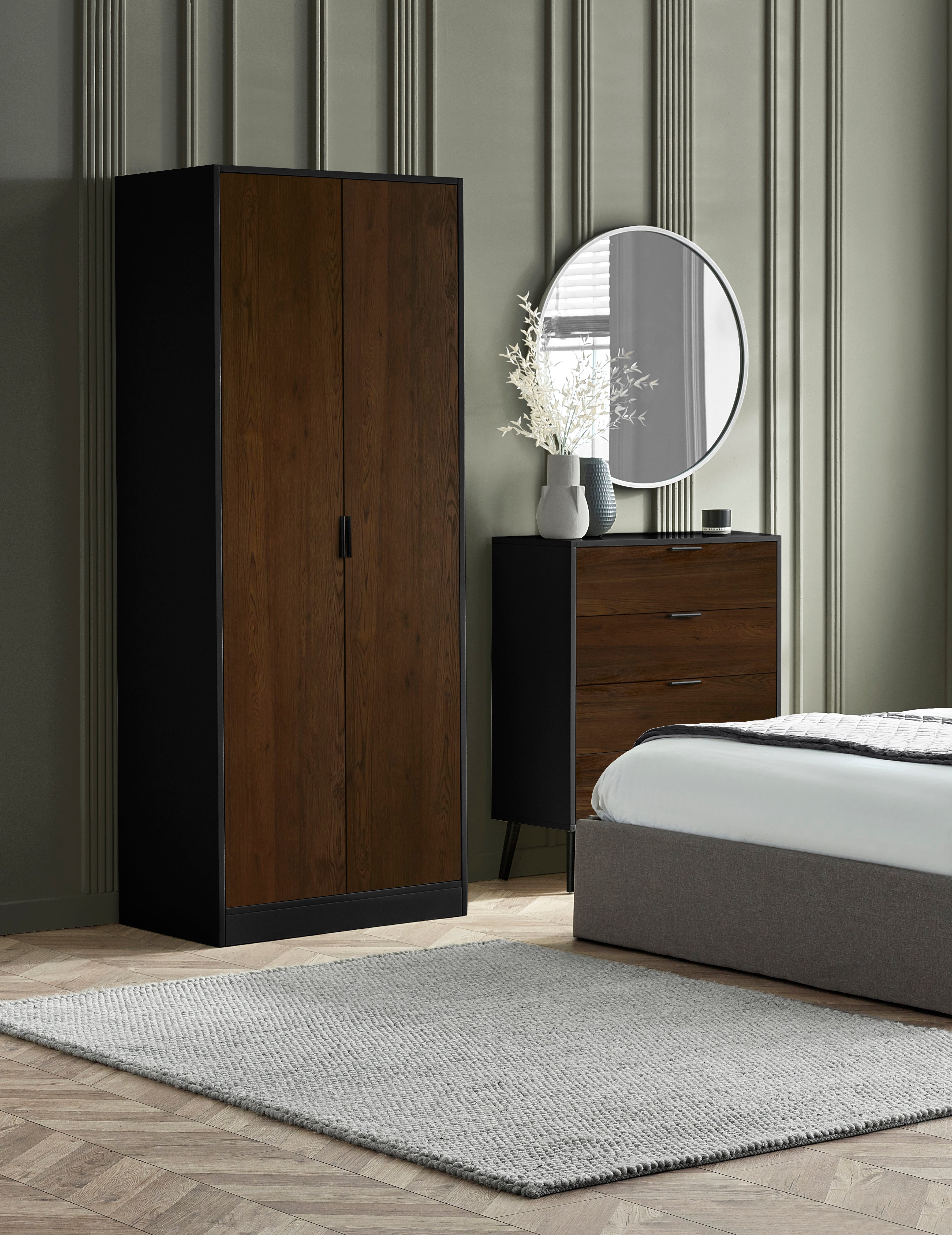 Bedroom with wooden wardrobe, dresser, and bed.