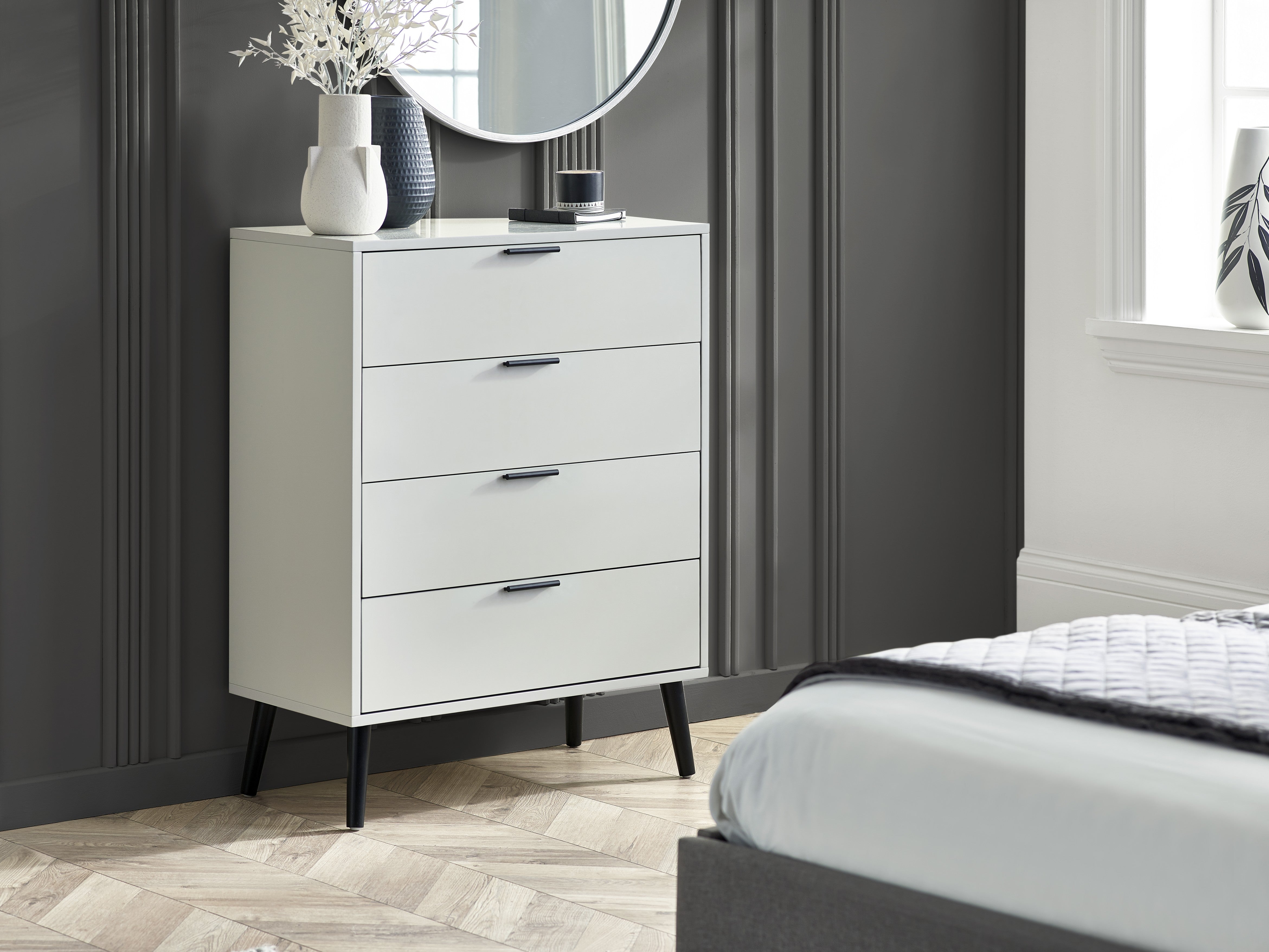 White dresser with black legs in a bedroom setting