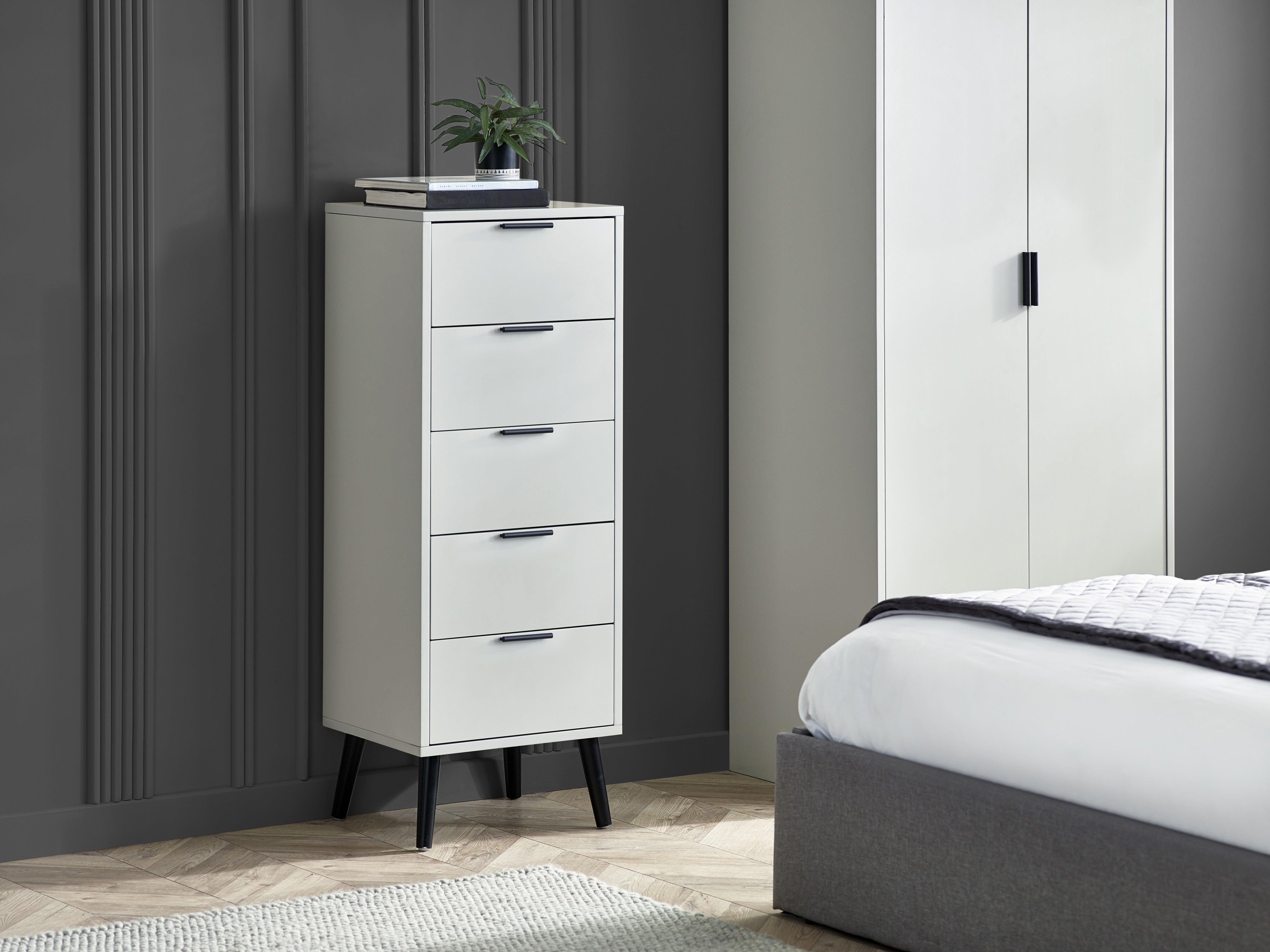 Tall grey dresser with multiple drawers in a bedroom setting.
