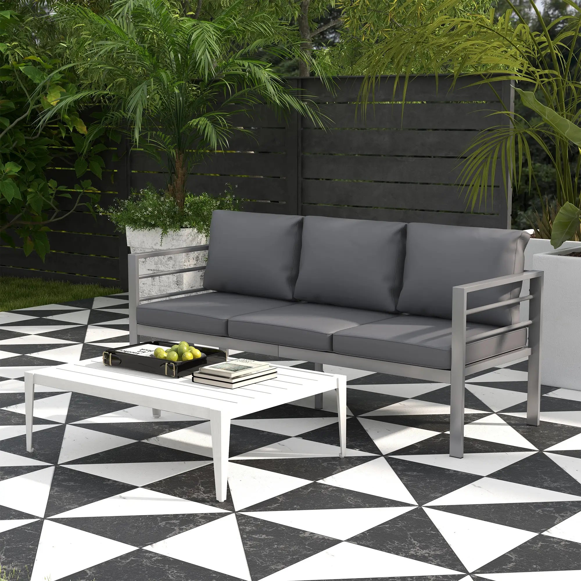 Gray outdoor sofa with cushions on a black and white checkered patio