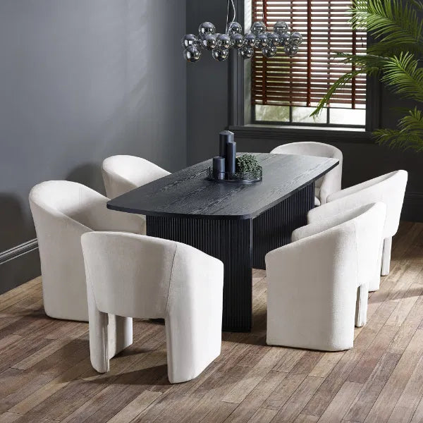 Dining room with a dark wooden table and white chairs on a wooden floor.