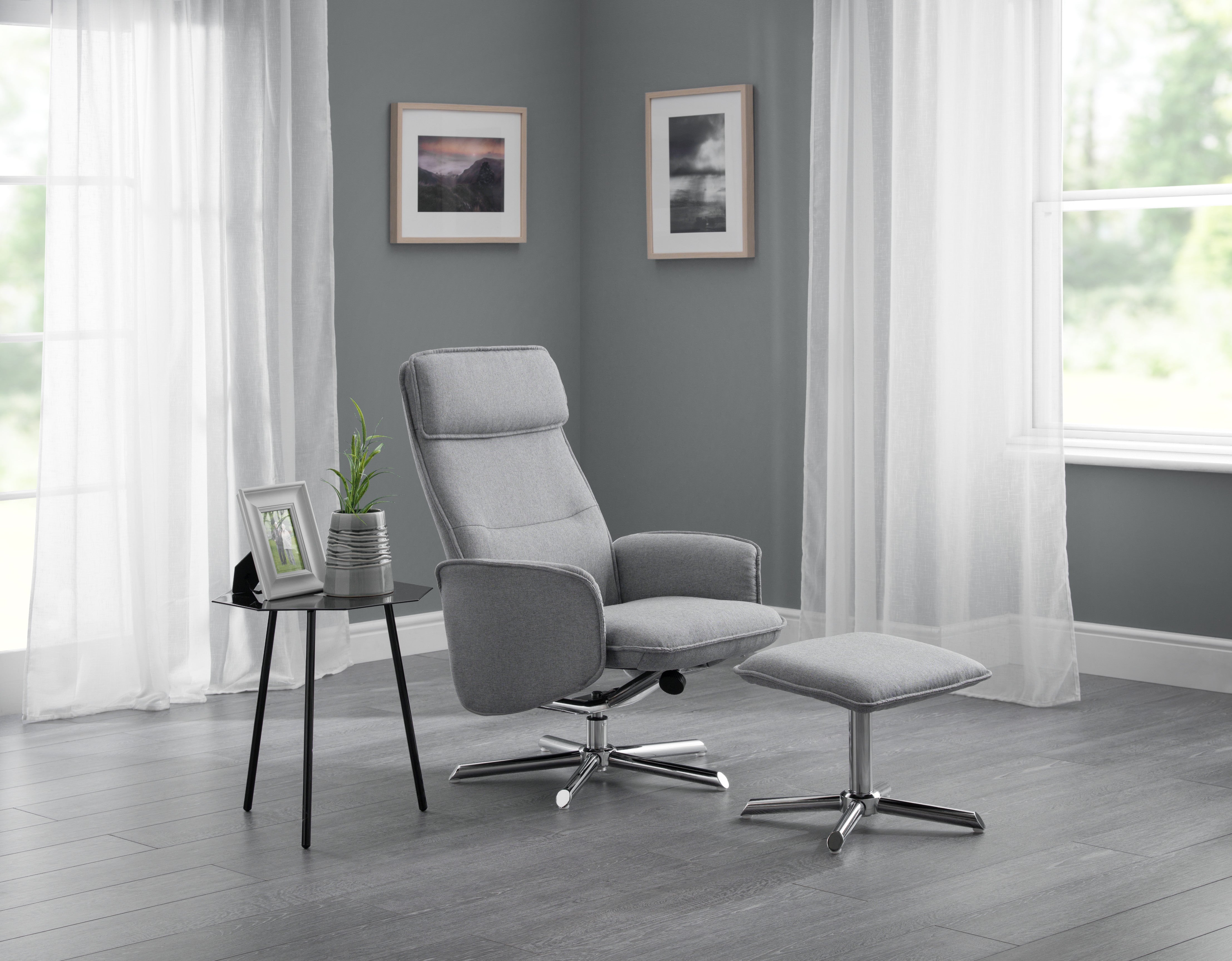 Gray recliner chair with ottoman in a room with gray walls and white curtains.