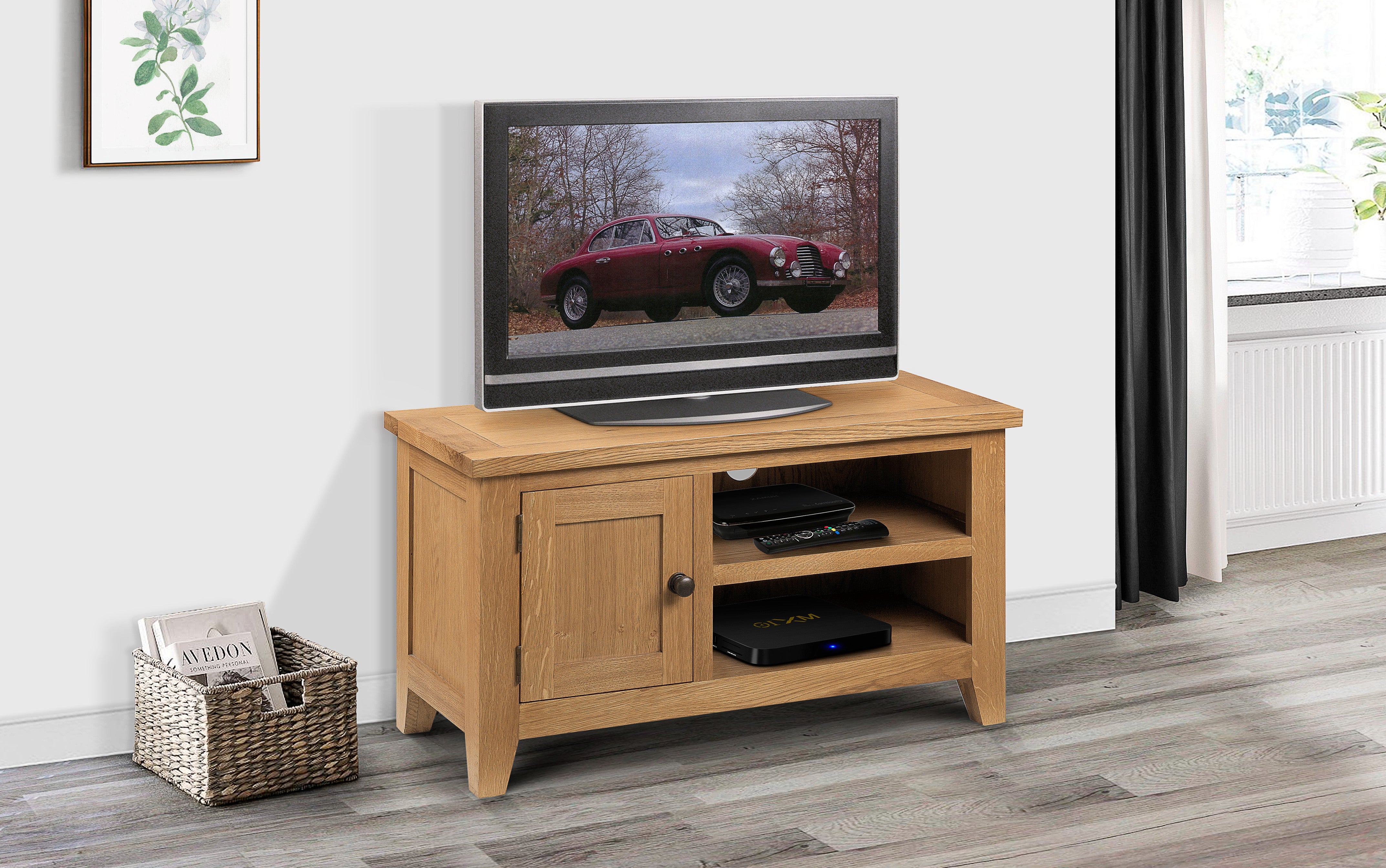 Wooden TV stand with a television displaying a car image, placed against a white wall.