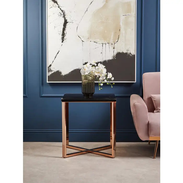 Modern living room with a pink armchair, black side table, and abstract art on the wall.