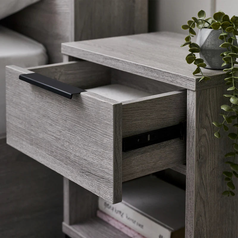 Wooden side table with an open drawer in a living room setting