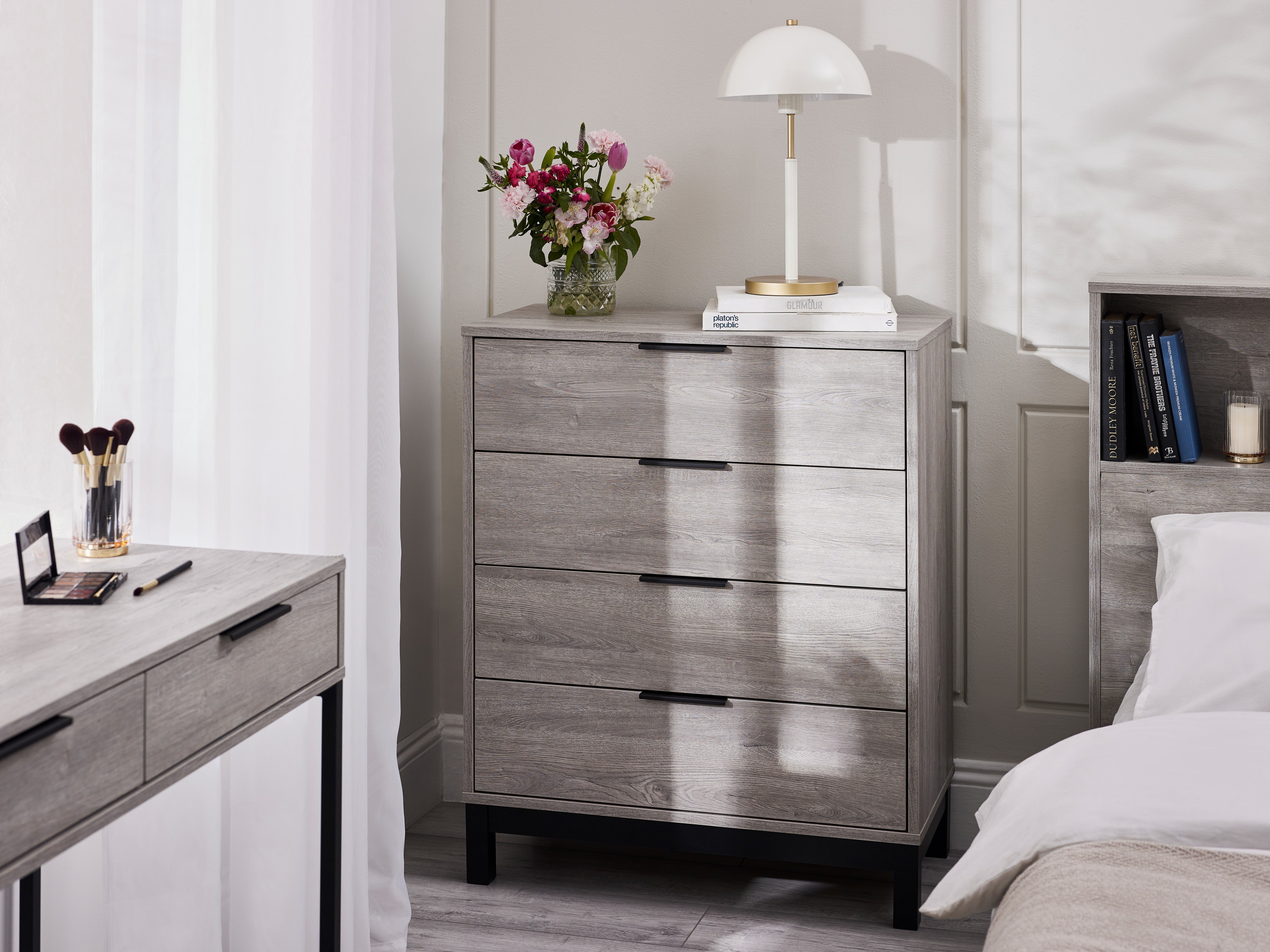 Gray dresser with floral arrangement in a bedroom setting