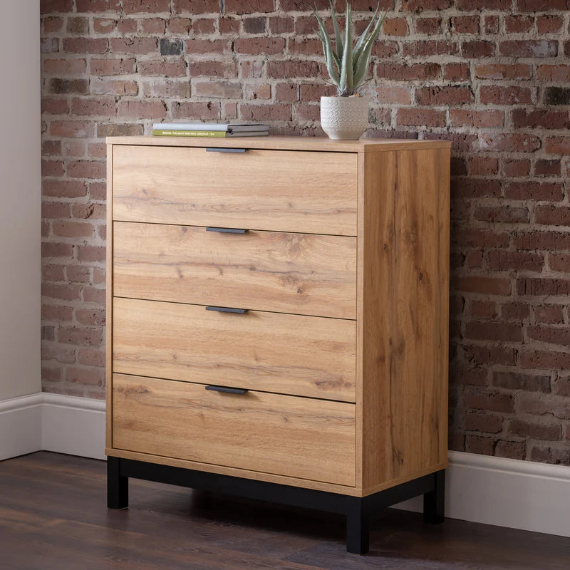 Wooden dresser with four drawers against a brick wall.
