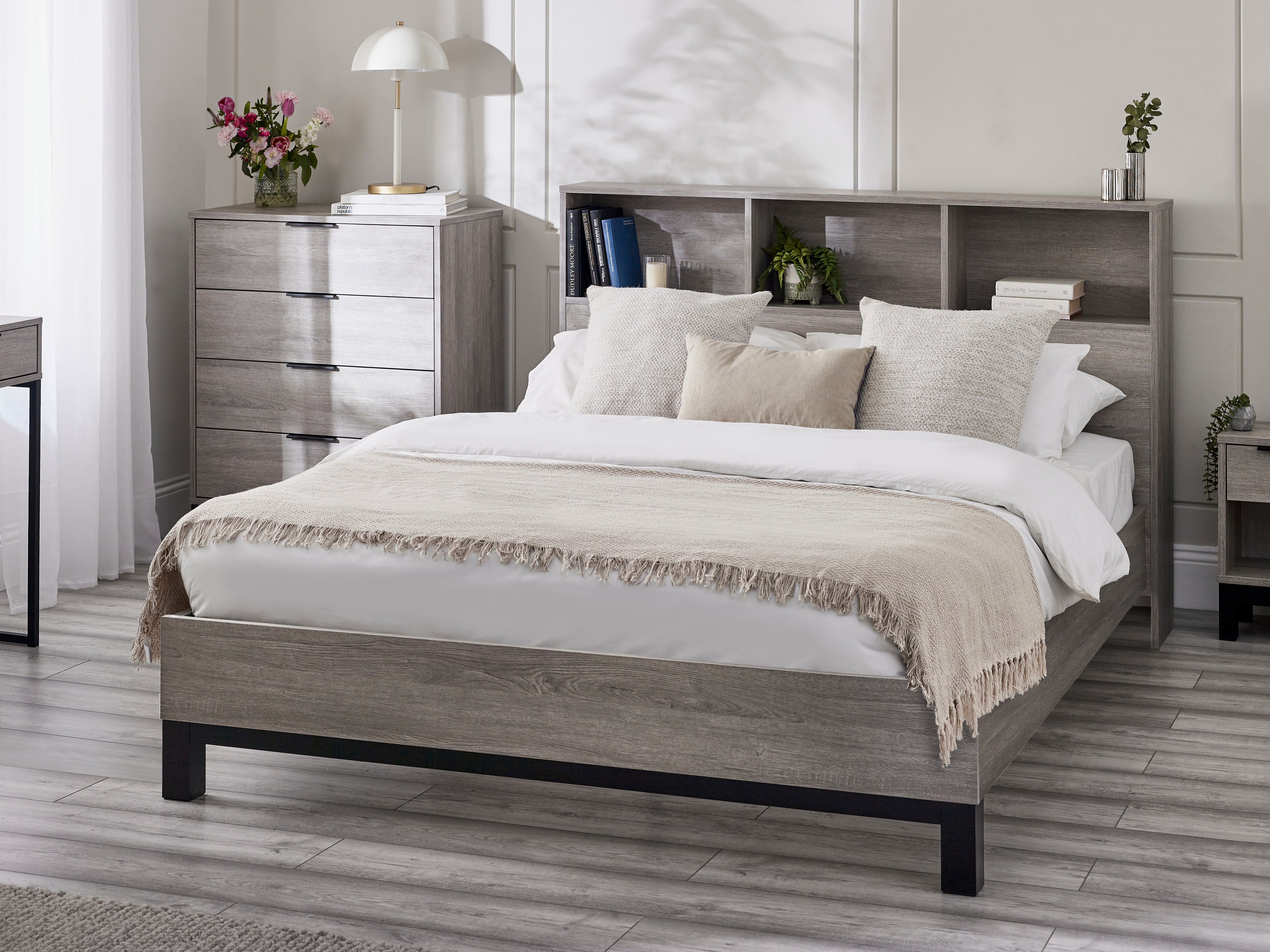 Bedroom with a wooden bed frame, white bedding, and decorative items.
