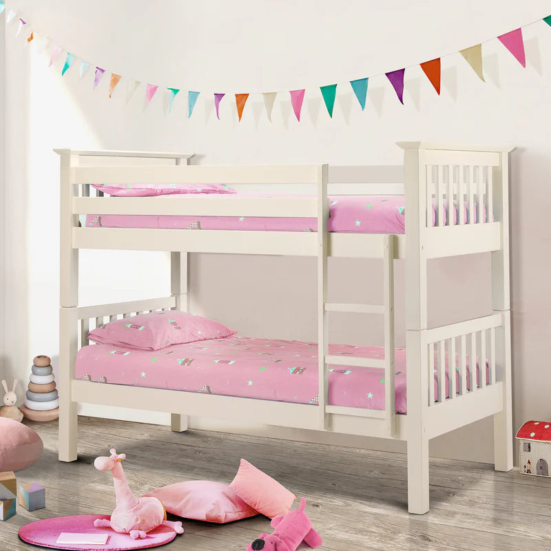 White bunk bed with pink bedding in a child's room with colorful flags and toys.