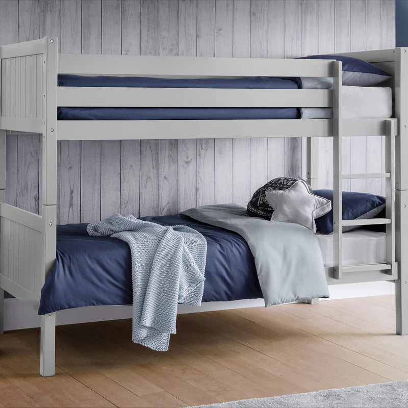 Bunk bed with blue bedding and gray blanket against a wooden paneled wall.