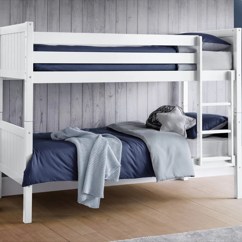 White bunk bed with blue bedding against a wooden paneled wall.