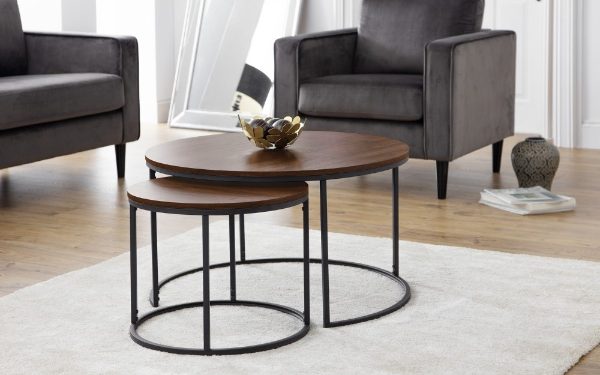 Set of three wooden coffee tables with metal legs in a living room setting.