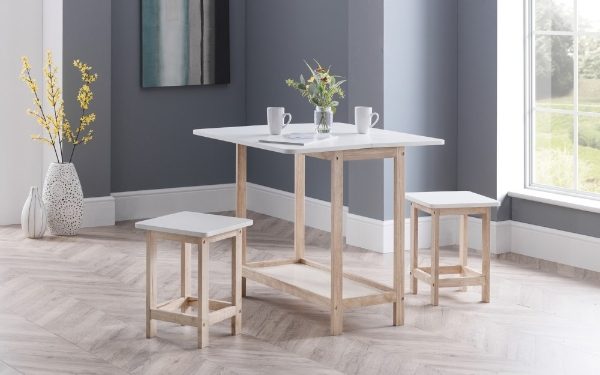 Dining table set with chairs and a vase of flowers in a room with a window and wall art.