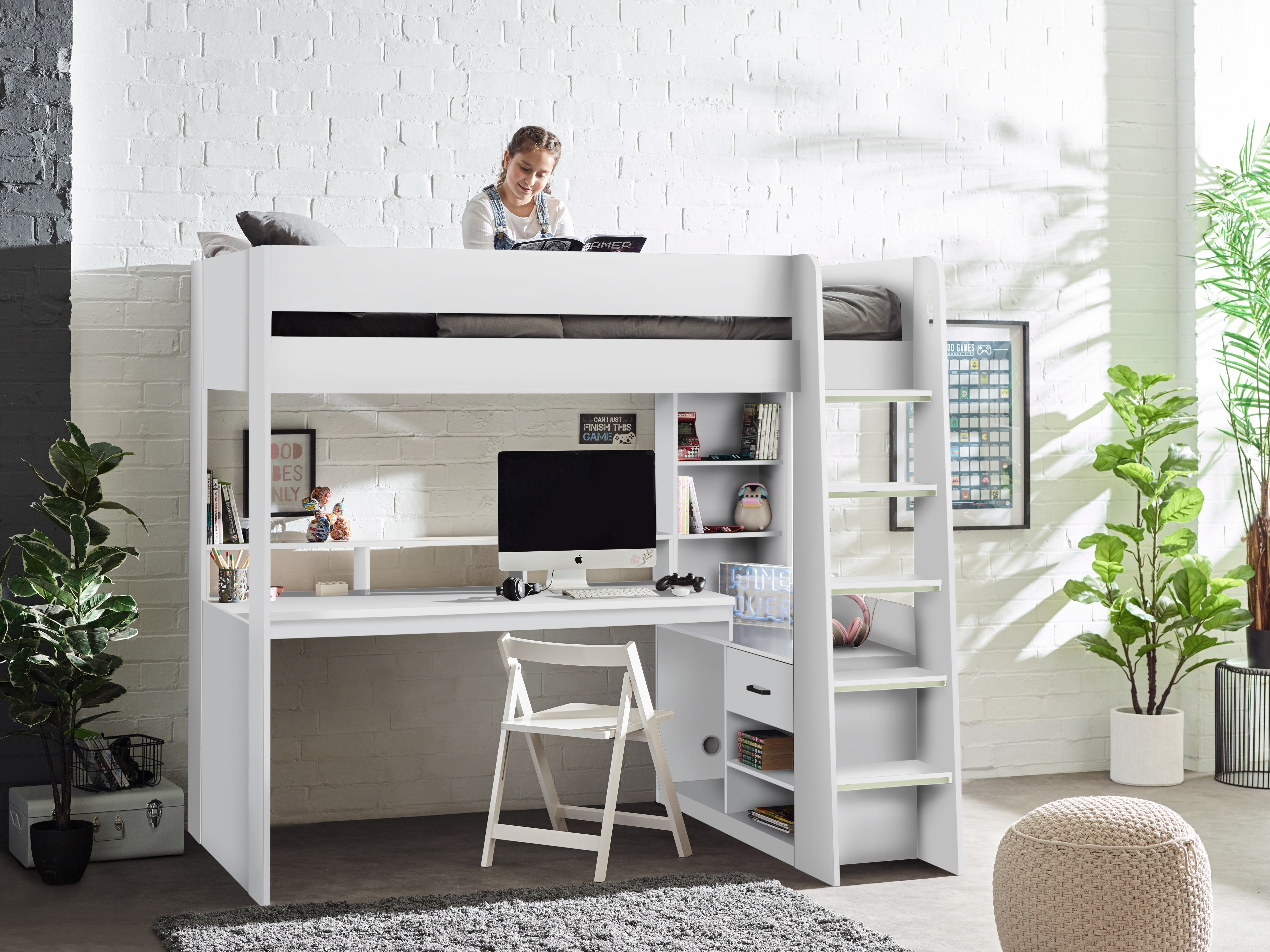 White loft bed with desk and shelves in a room with plants and a person working.