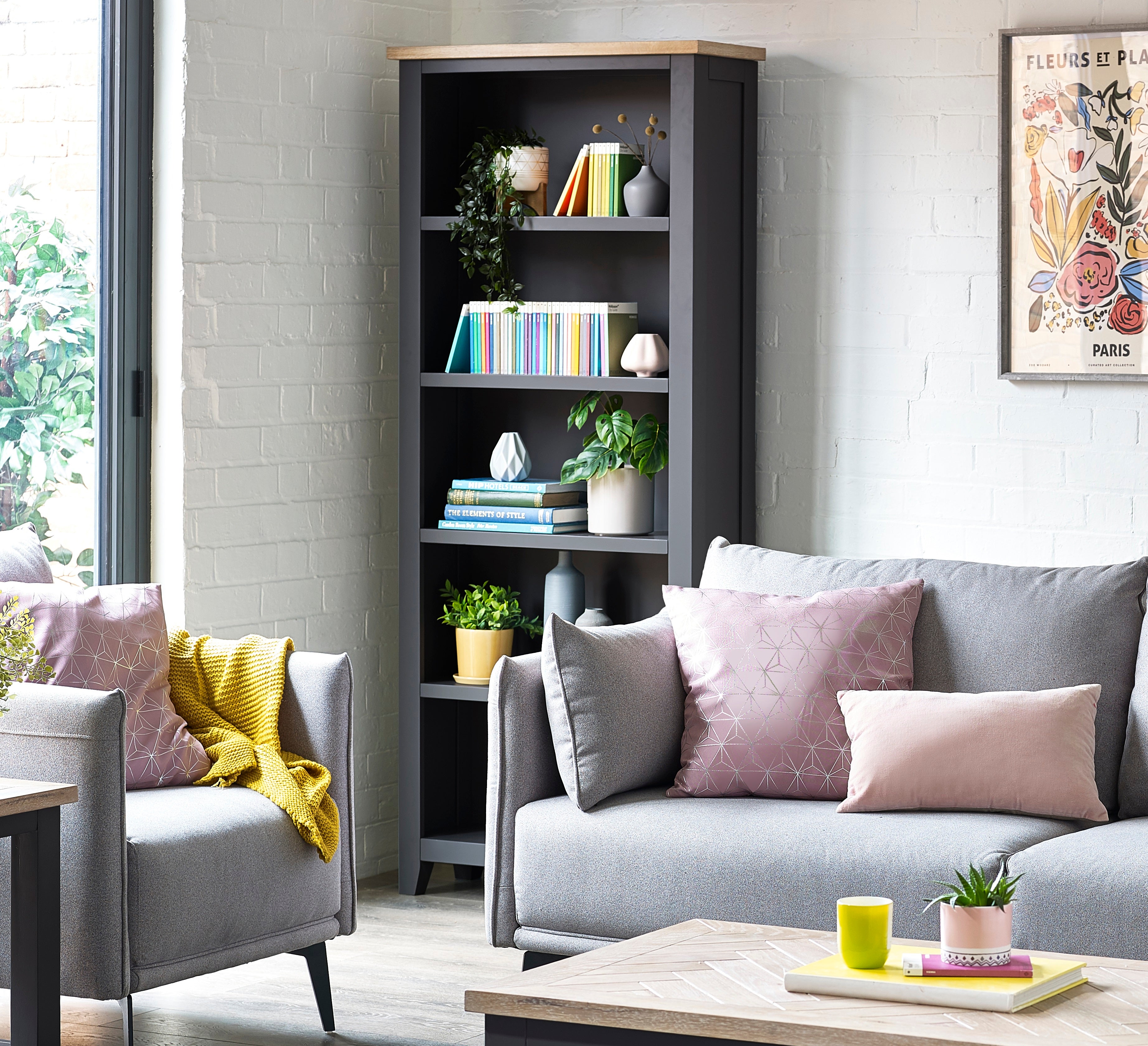 Living room with gray sofa, bookshelf, and decorative items.