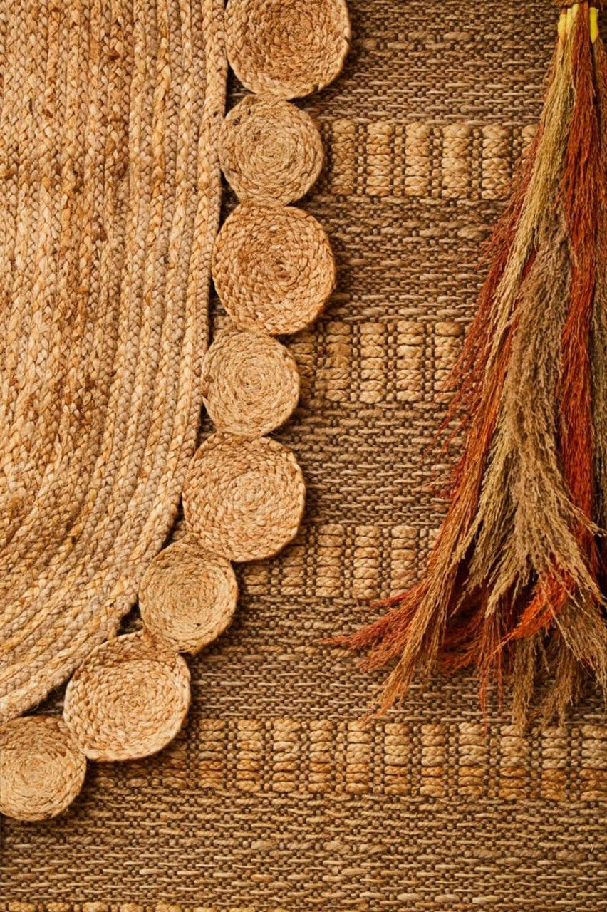 Close-up of a textured brown fabric with circular patterns and tassels.