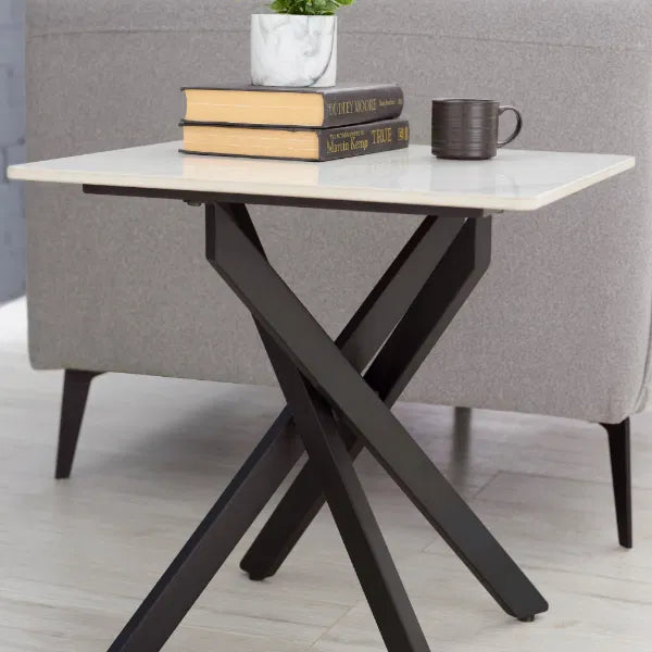 Small table with marble top and black metal legs, featuring books and a mug.