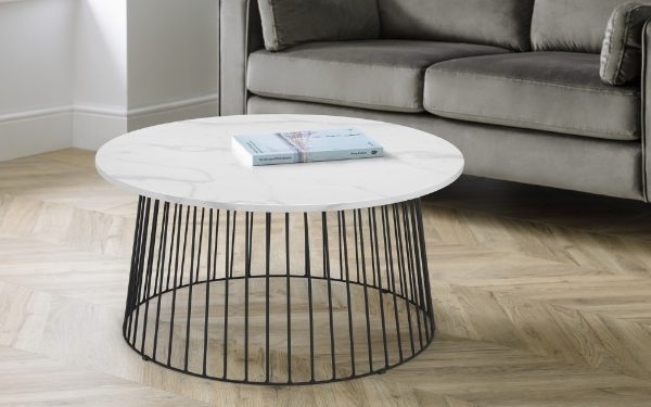 Round coffee table with marble top and black metal base in a living room setting.