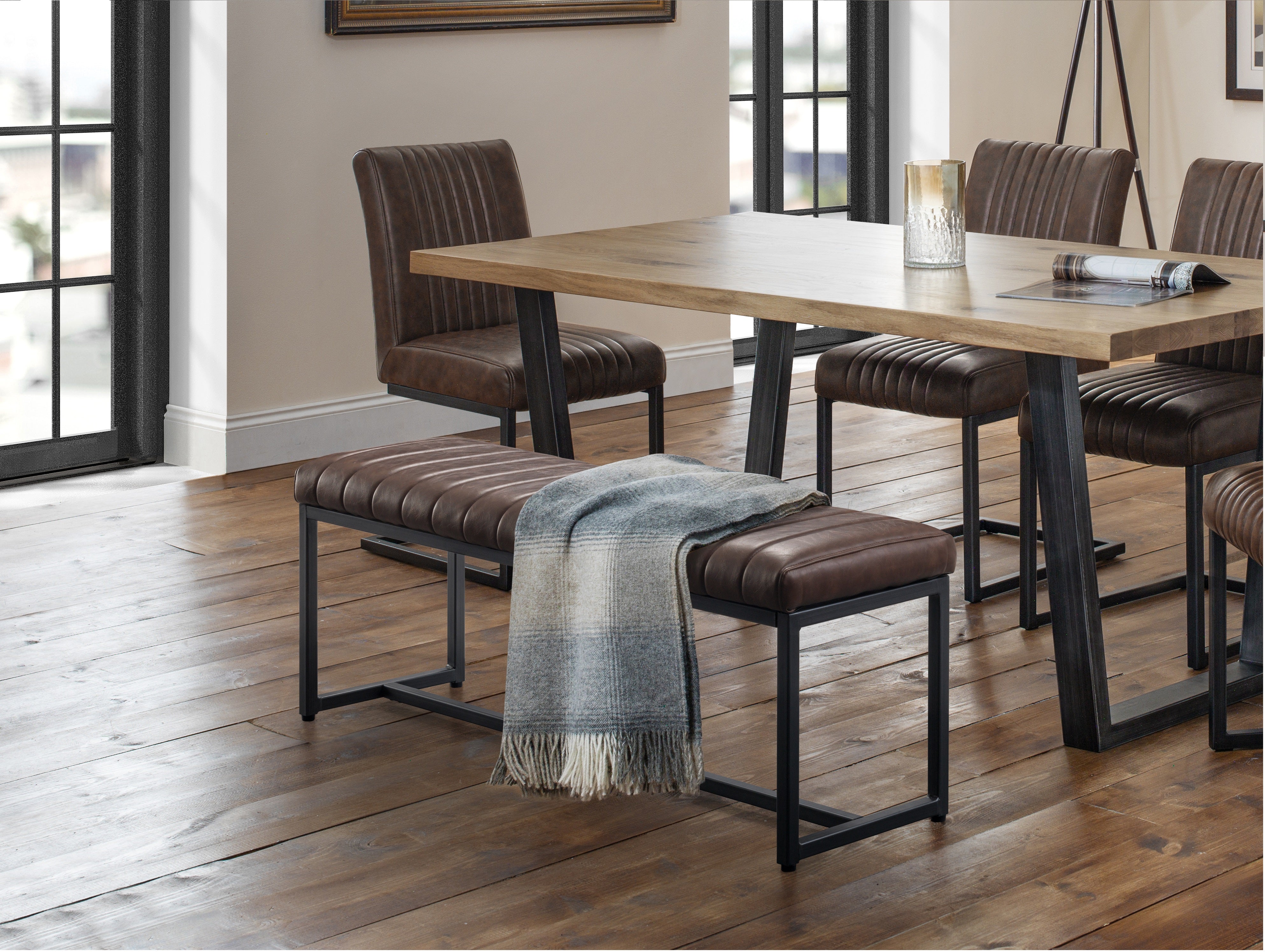 Dining area with wooden table and brown chairs in a well-lit room.