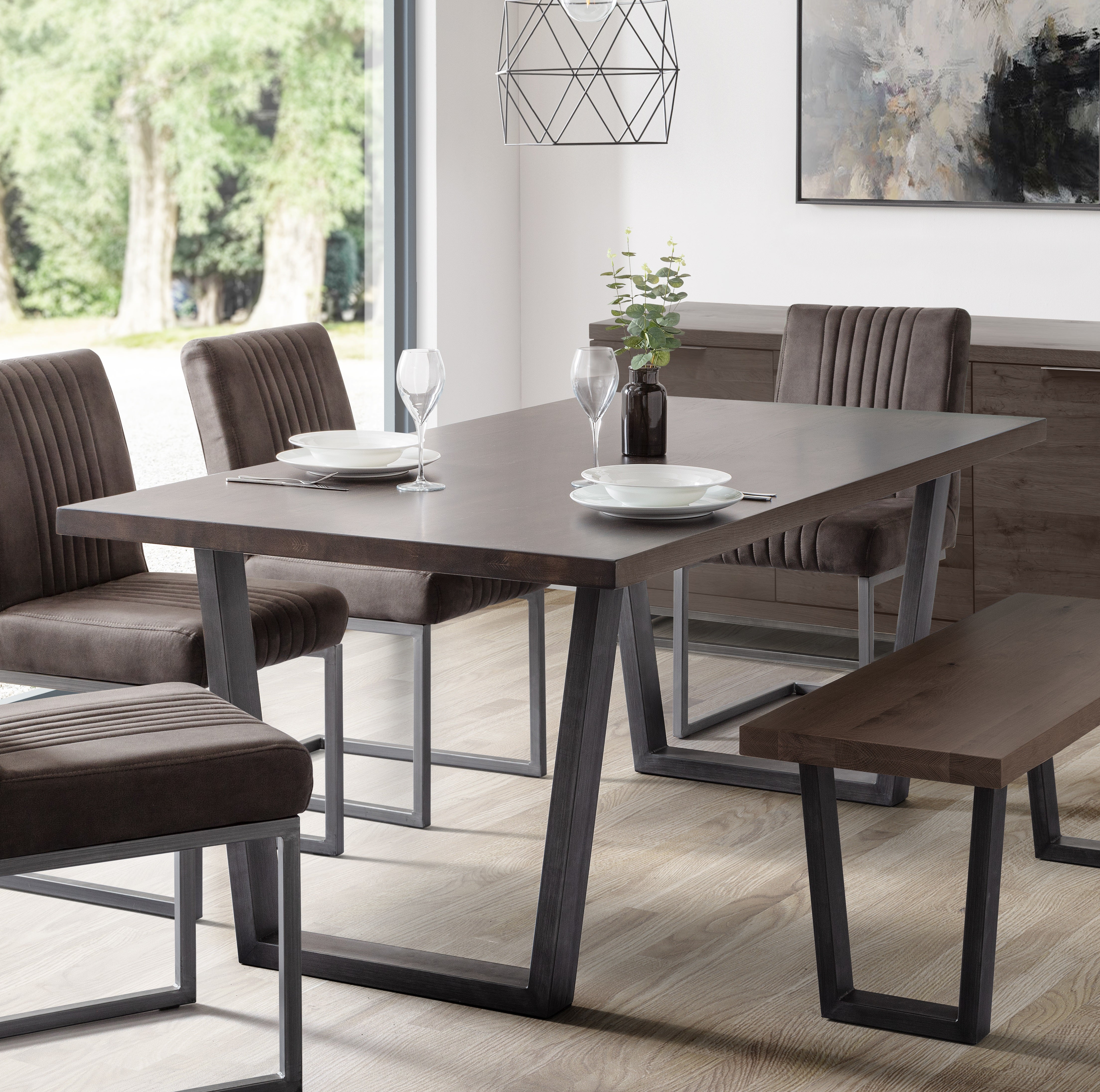 Dining room with a dark wooden table and chairs in a modern setting.