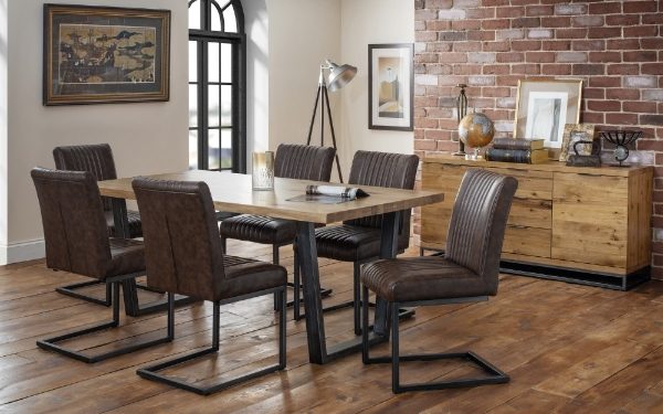 Dining room with wooden table and chairs against a brick wall.