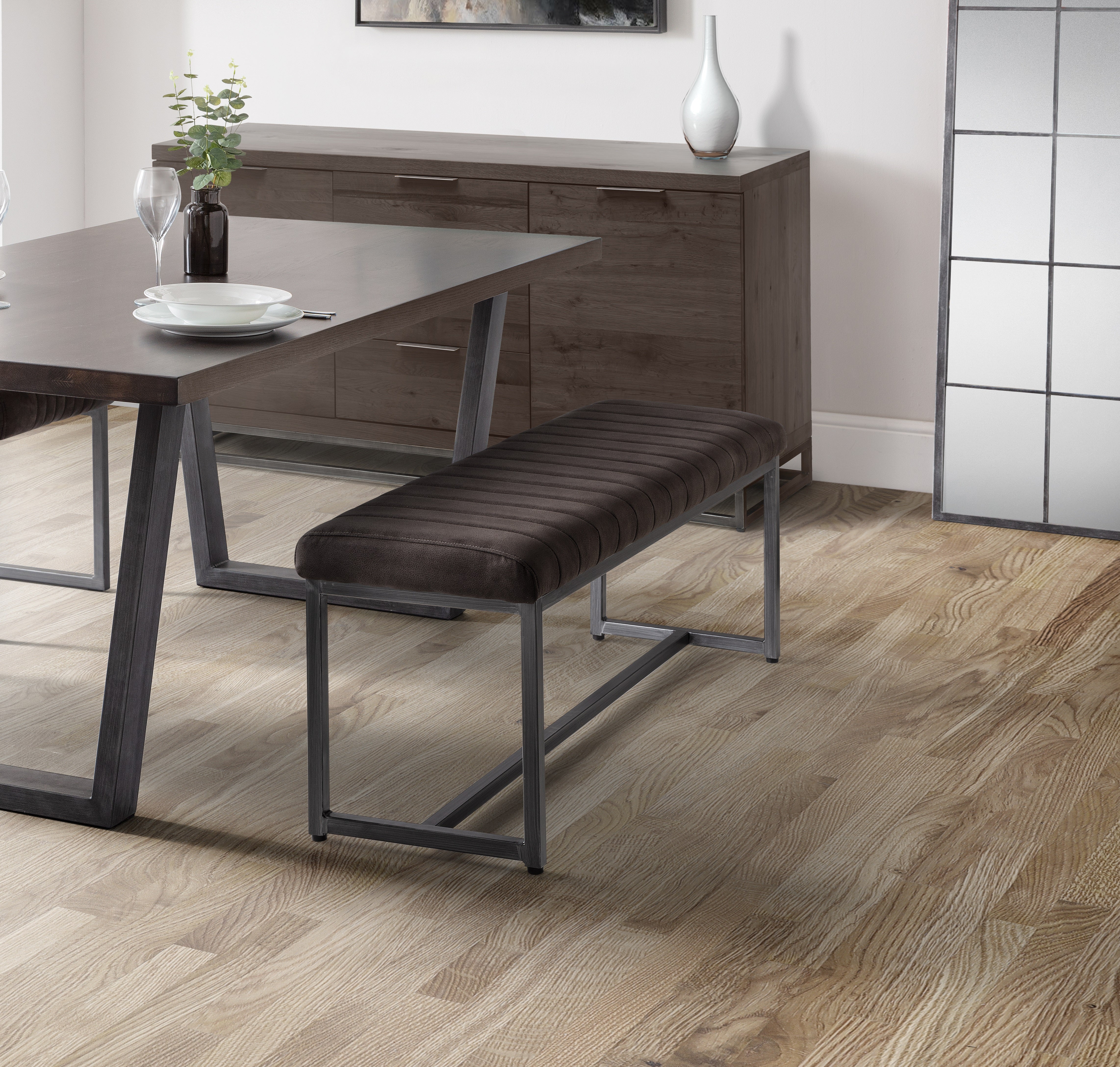 Dining room with a dark wood table and bench on a wooden floor.