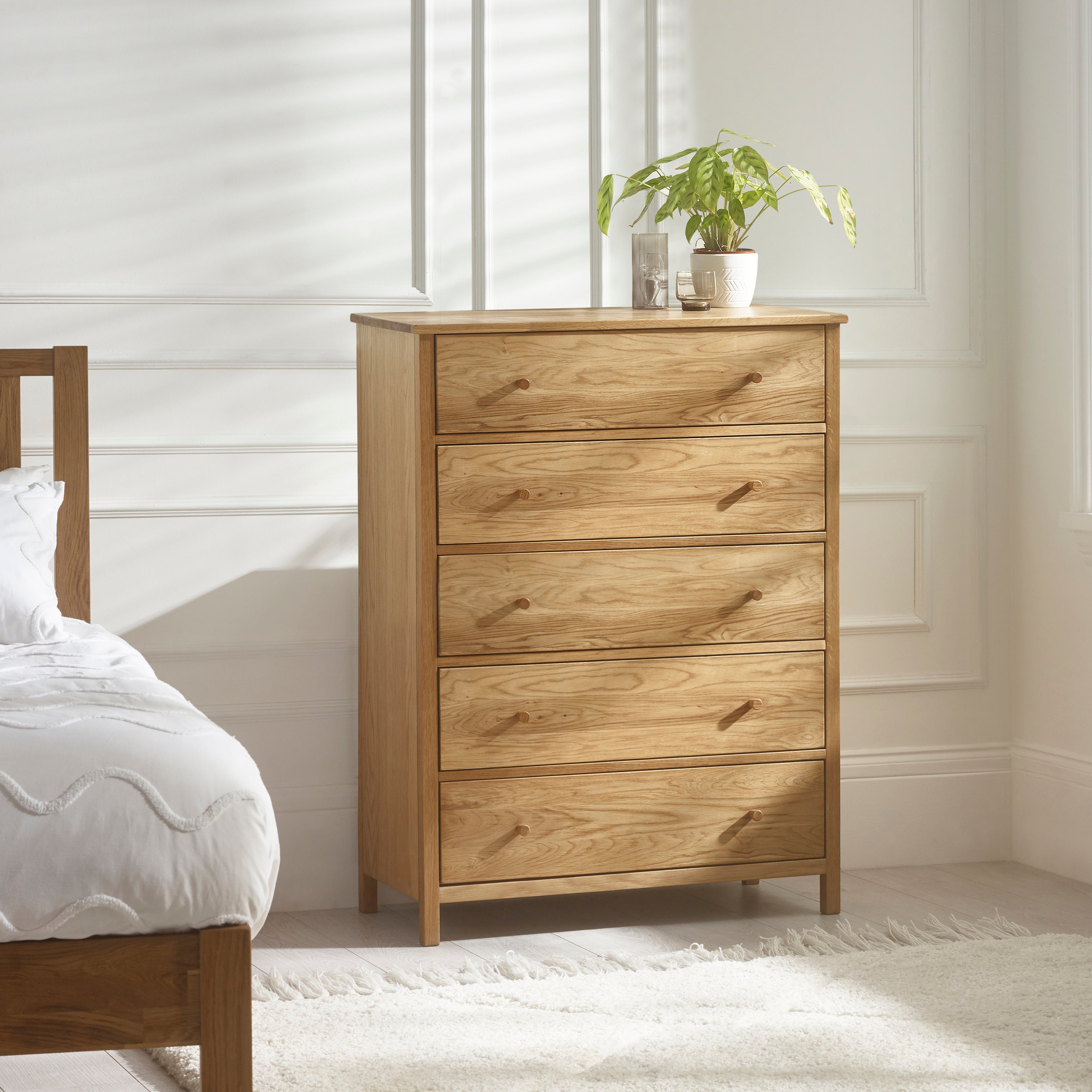 Wooden dresser with three drawers in a bedroom setting.