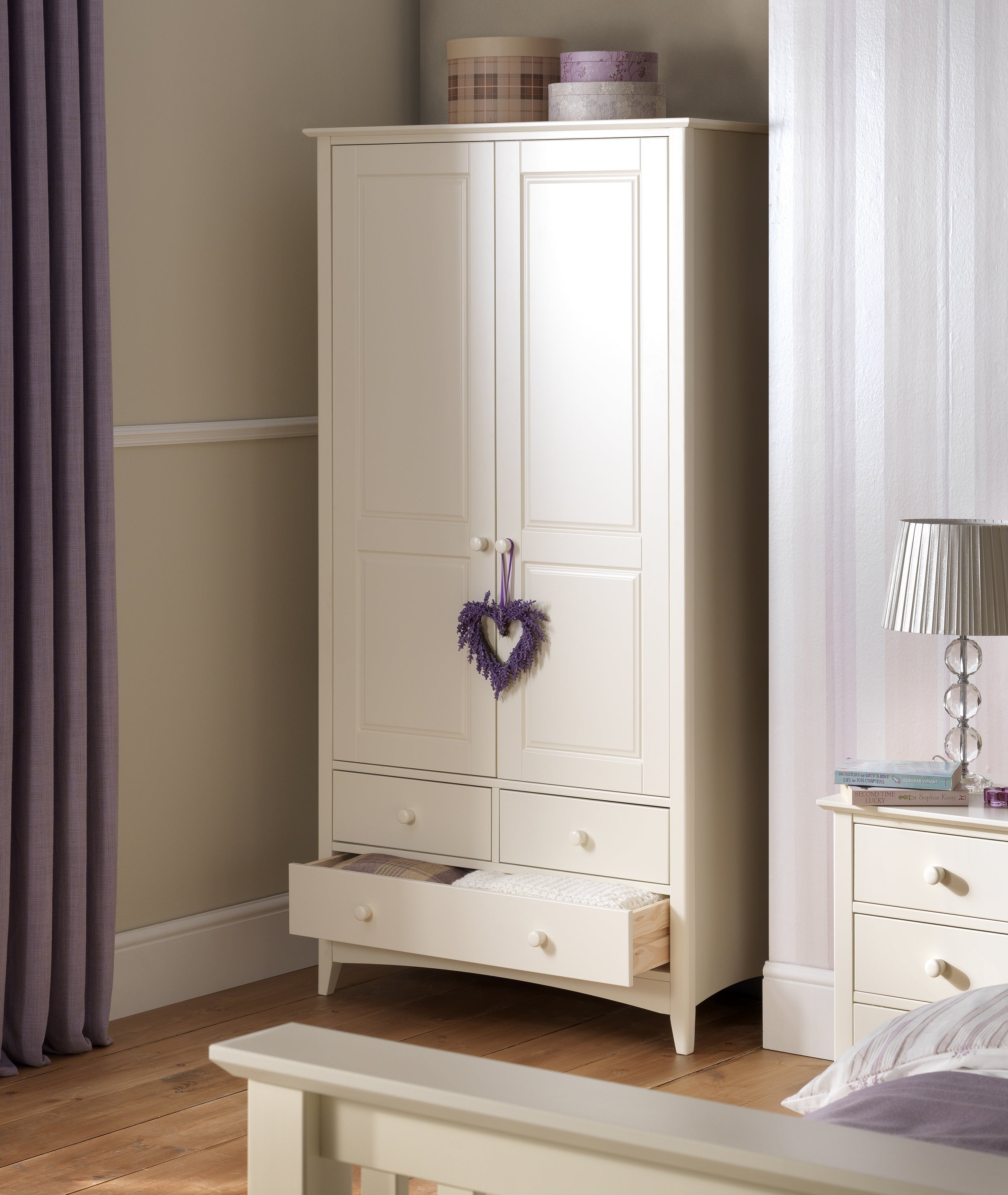 White wardrobe with a heart decoration in a bedroom setting