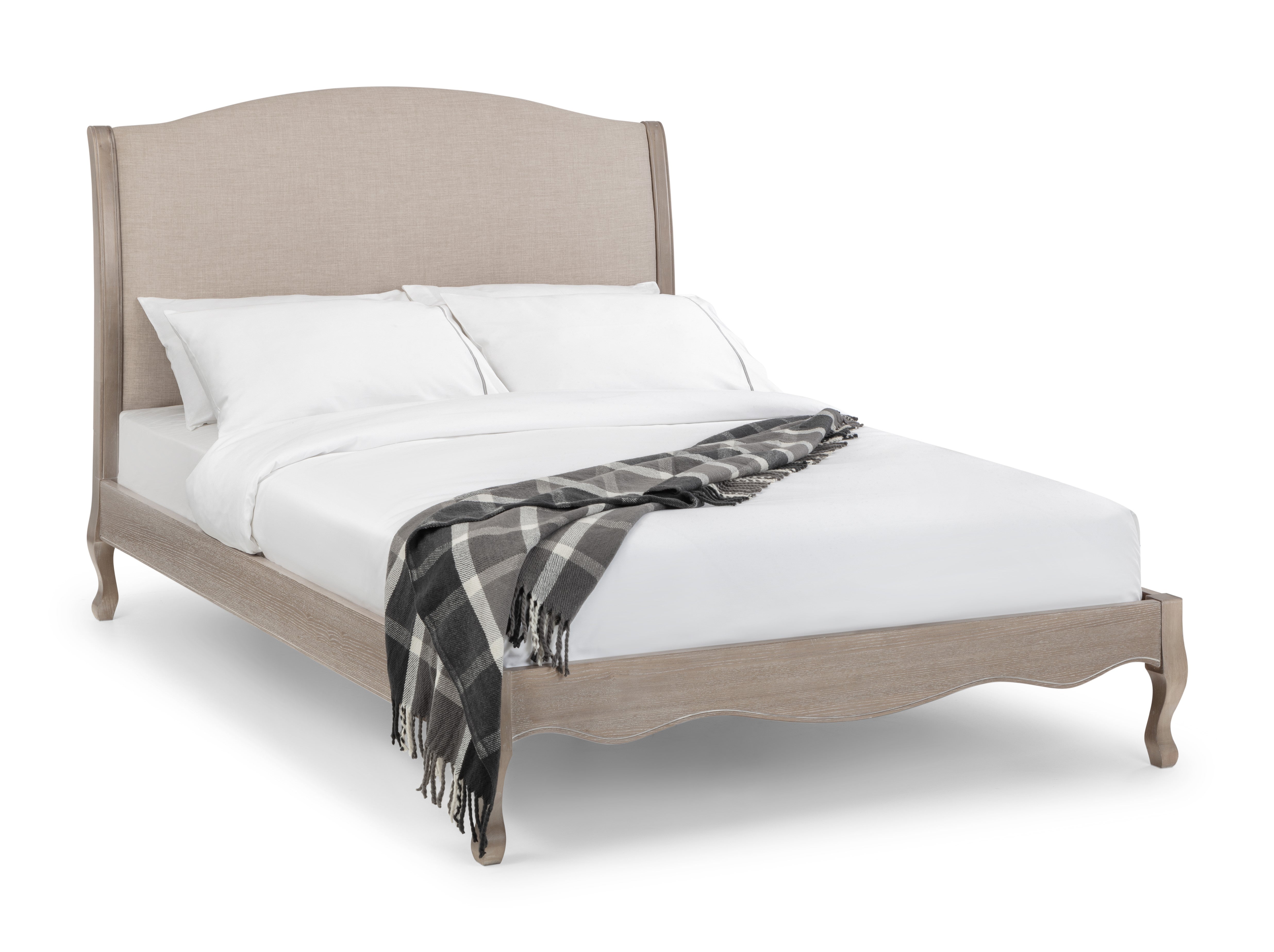 Bed with beige headboard and plaid blanket on a white background