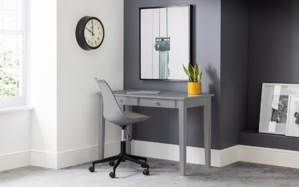 Gray desk with chair in a room with a clock and framed pictures on the wall.