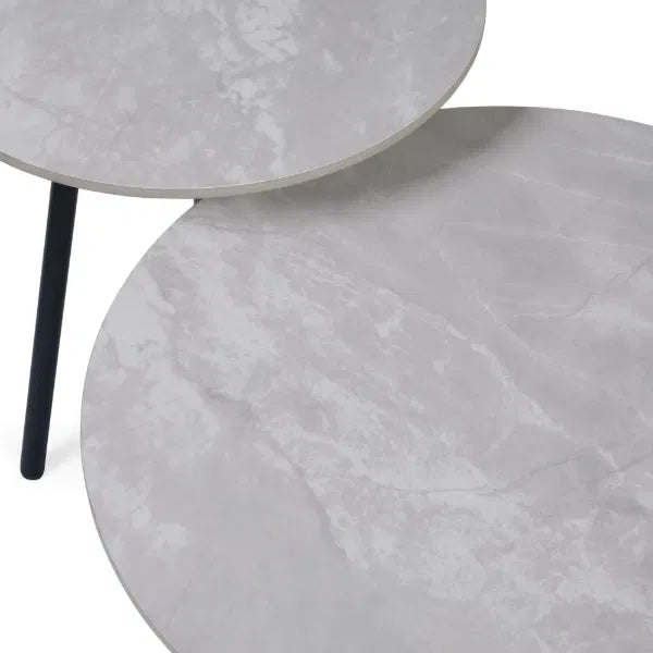 Two gray marble side tables with a black leg on a white background