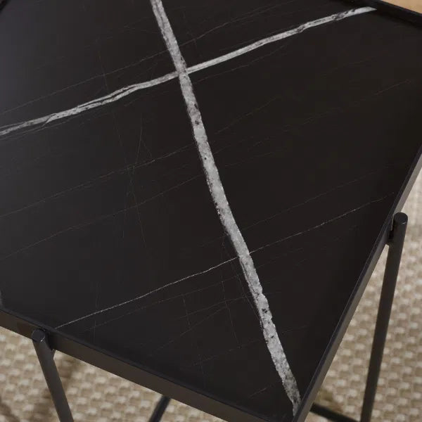 Black marble table with white veins on a textured surface