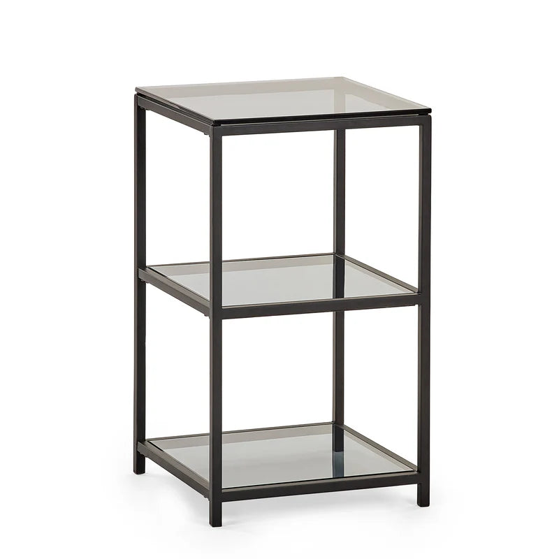 Three-tiered glass side table with black metal frame on a white background