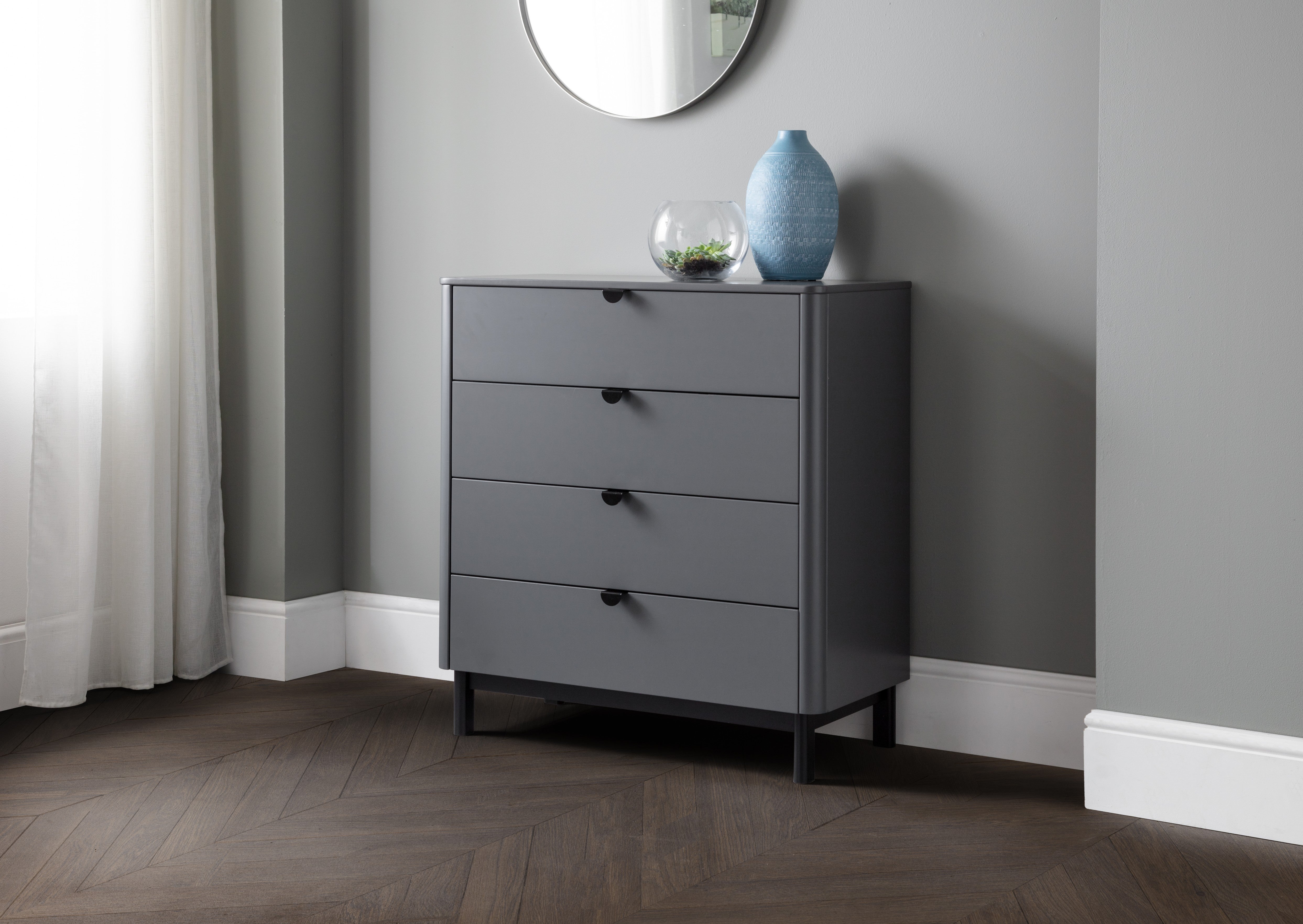 Gray dresser with decorative items against a gray wall