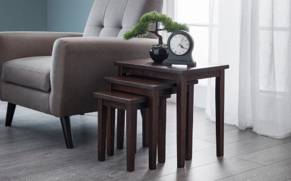 Set of wooden nesting tables in a living room setting with a clock and plant.