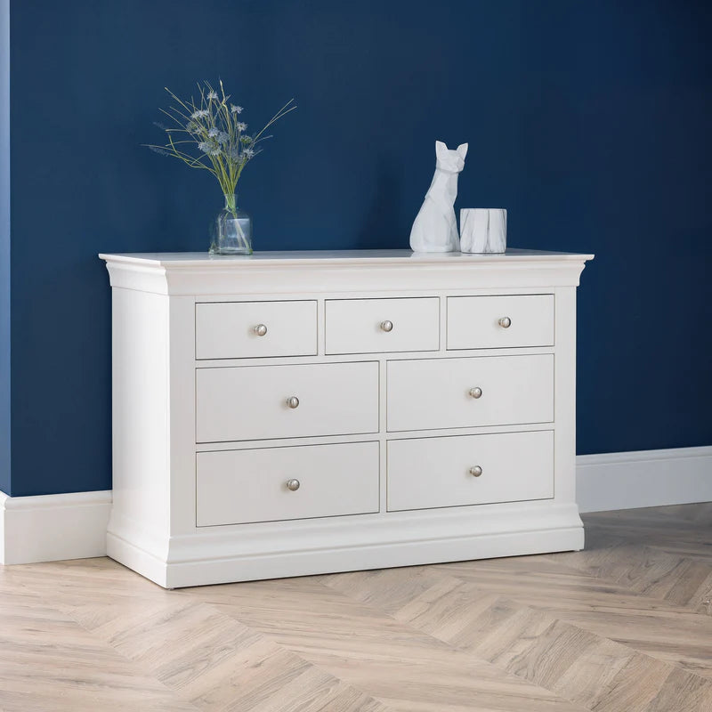 White dresser with decorative items against a blue wall