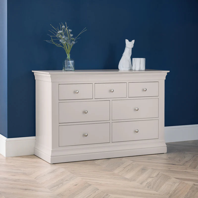 Light gray dresser with decorative items against a blue wall