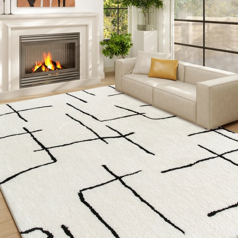 Living room with a white rug featuring black abstract patterns, a beige sofa, and a fireplace.