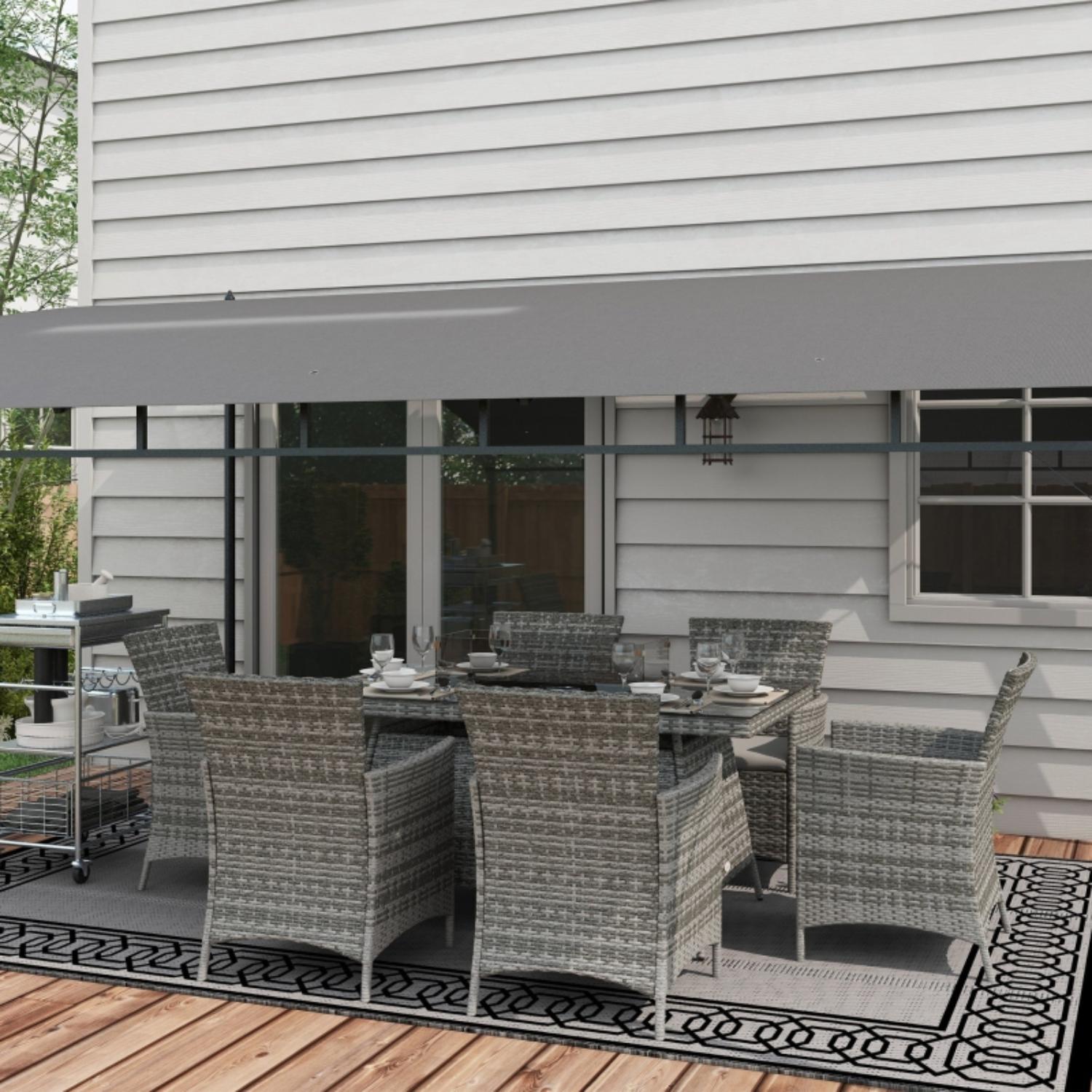 Outdoor patio set with table and chairs on a deck in front of a house.