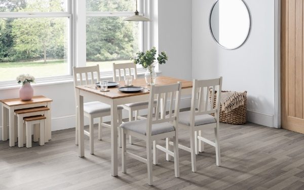 Dining area with wooden table and chairs in a bright room.