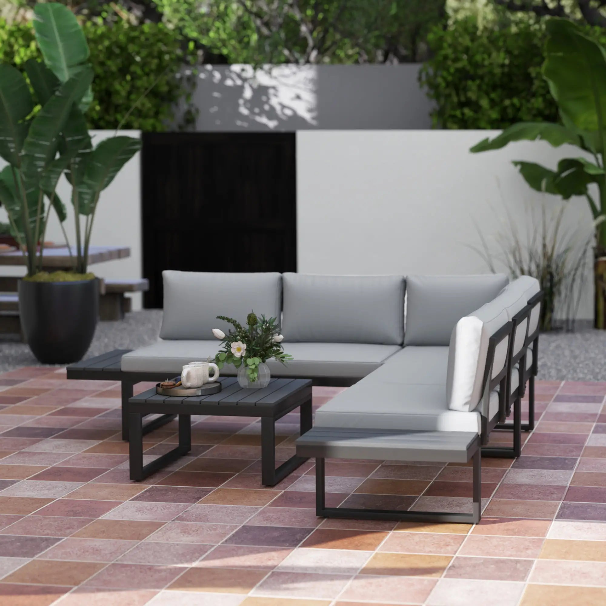 Outdoor patio furniture set with gray cushions on a tiled patio