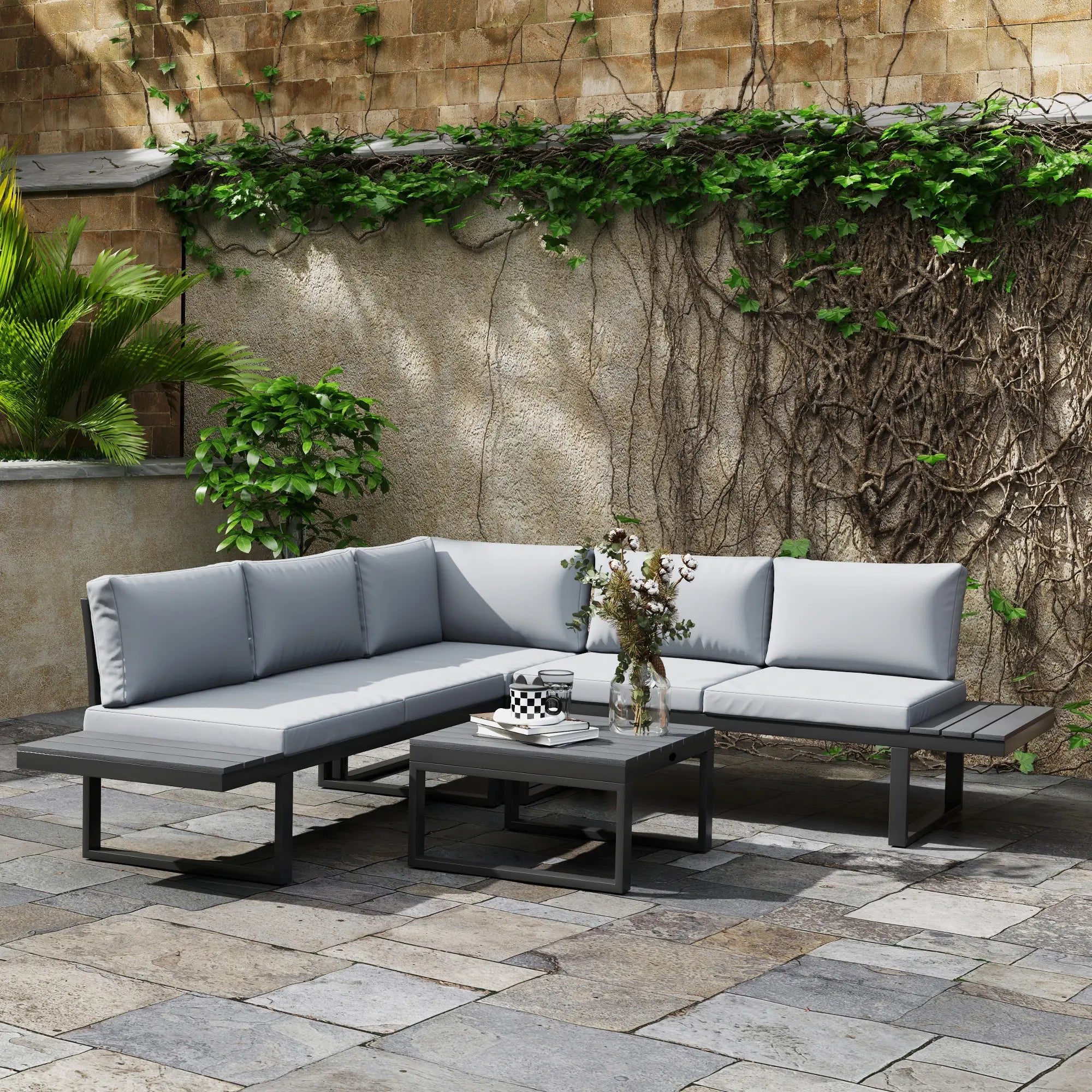 Outdoor patio furniture set with gray cushions on a stone patio.