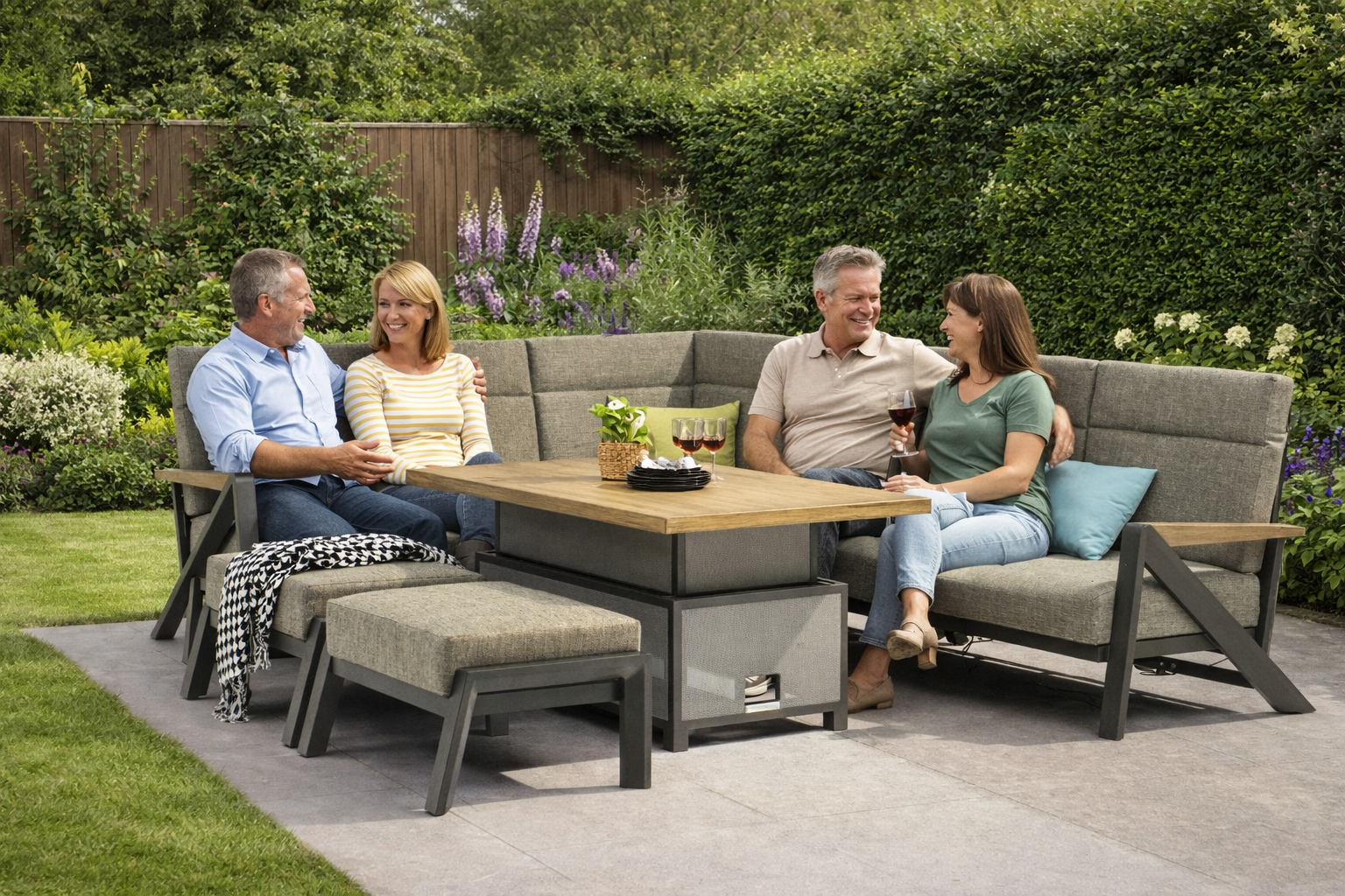 Two couples sitting on a patio set with a table, enjoying each other's company.