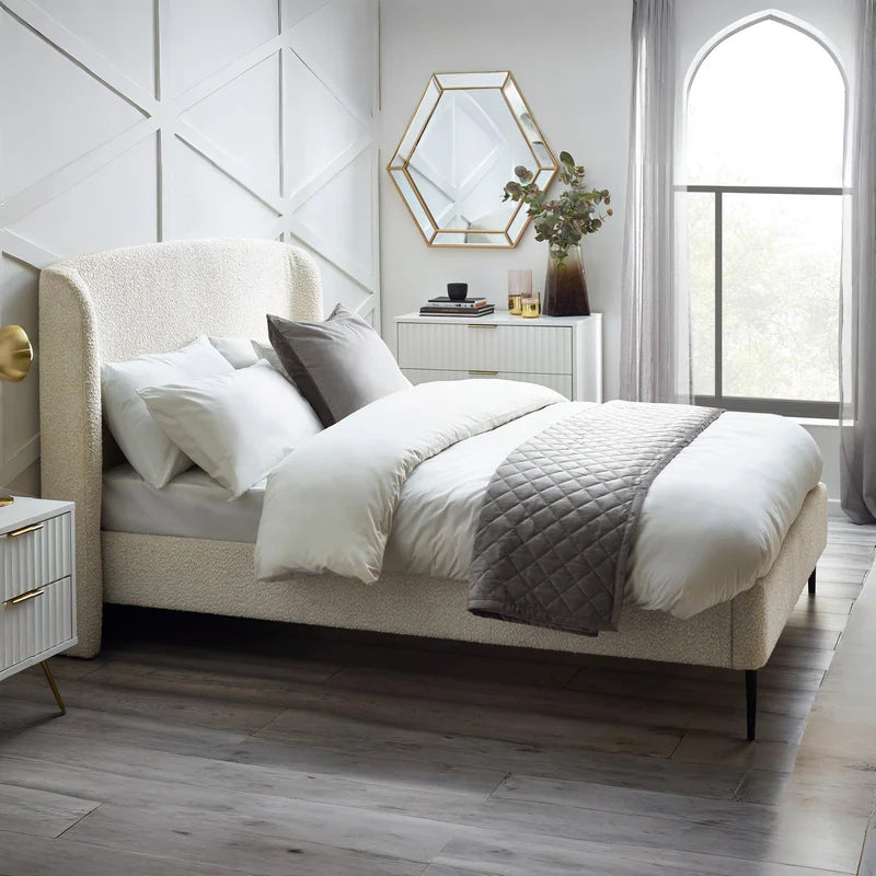 Modern bedroom with a bed, nightstands, and decorative elements.