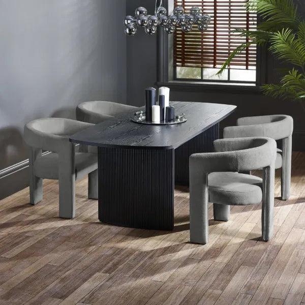 Dining room with a black table and gray chairs on a wooden floor.